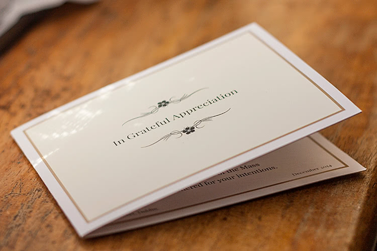 4-page folding acknowledgement card placed on a wooden surface.
