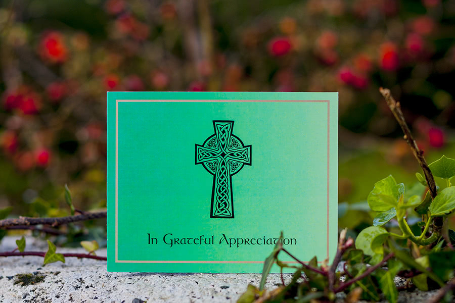 AC7 acknowledgement card design, double sided. Green background, large black Celtic cross. Outdoors, wild rose in background.