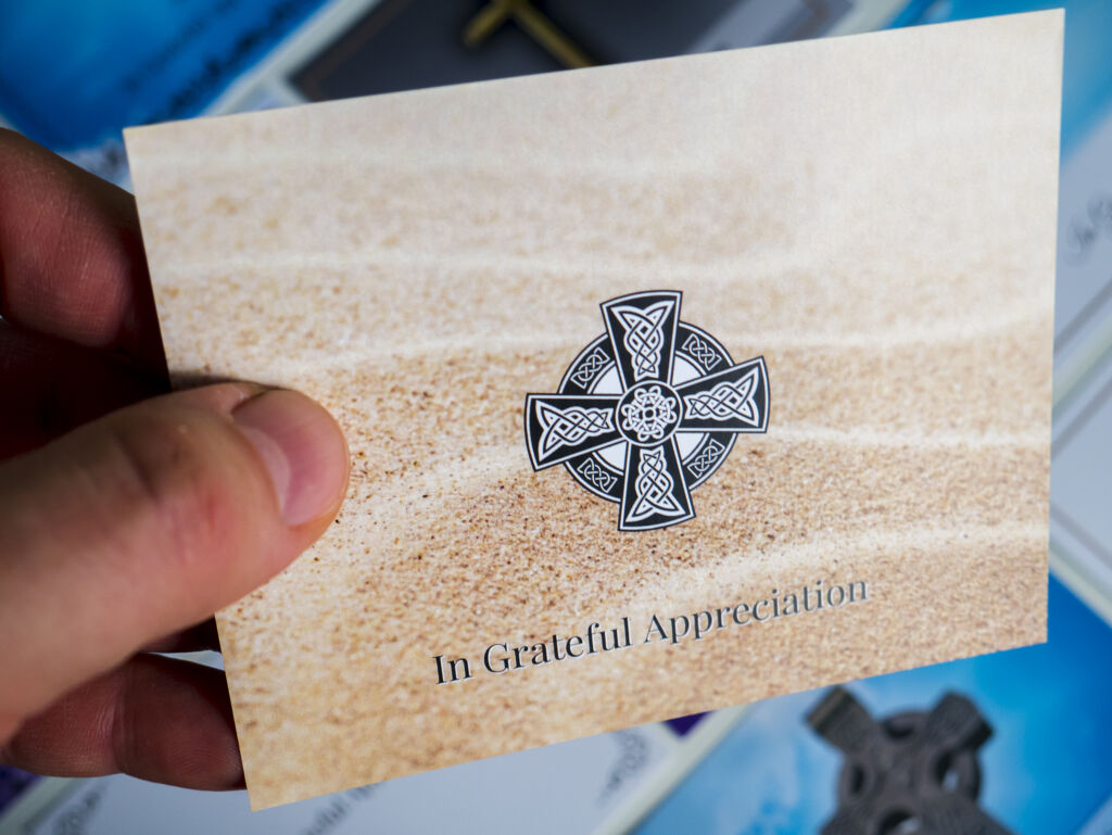 Front of a double sided acknowledgement card with sand pattern background and black decorative Irish/Celtic cross