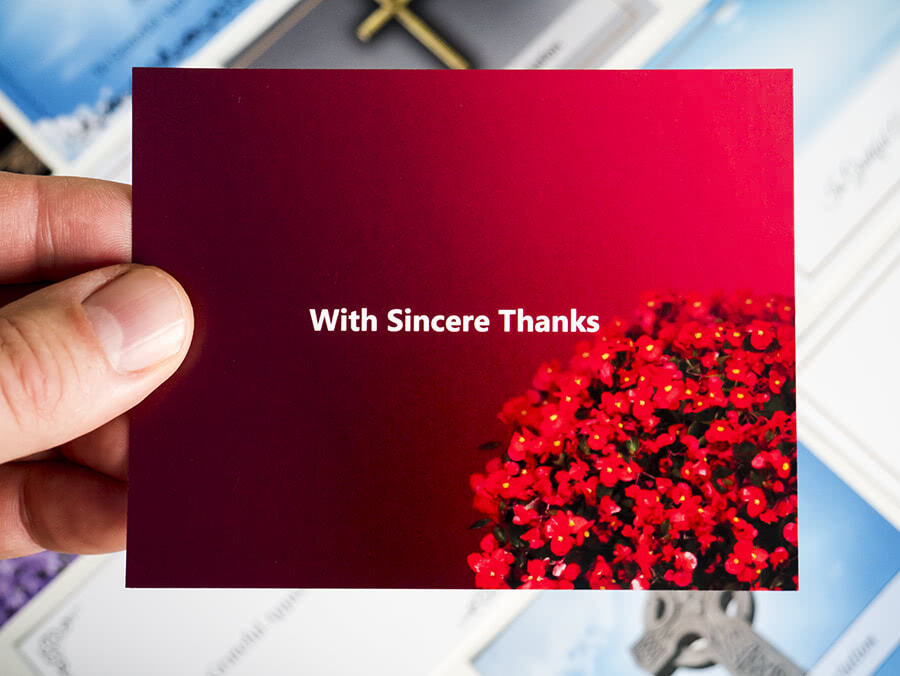 Red acknowledgement card with bunch of flowers in the corner and "With Sincere Thanks" writing in the center. 