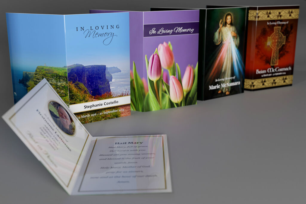 4 different memorial cards: Scenic, Floral, Religious and Irish/Celtic. Inside of a card visible in the foreground.