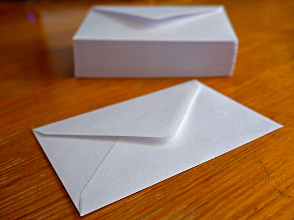 Envelope and a stack of envelopes in the background, shallow DOF.